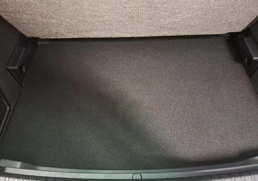 Vue rapprochée du plancher de chargement variable du coffre du Skoda Karoq blanc lune, sans chargement visible.