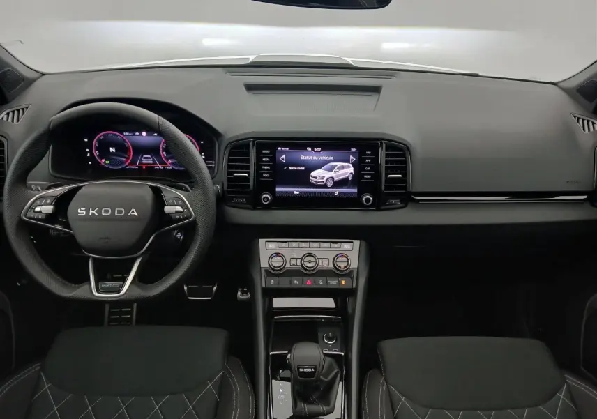 Vue intérieure frontale du tableau de bord et volant SKODA KAROQ avec écran tactile et commandes numériques.