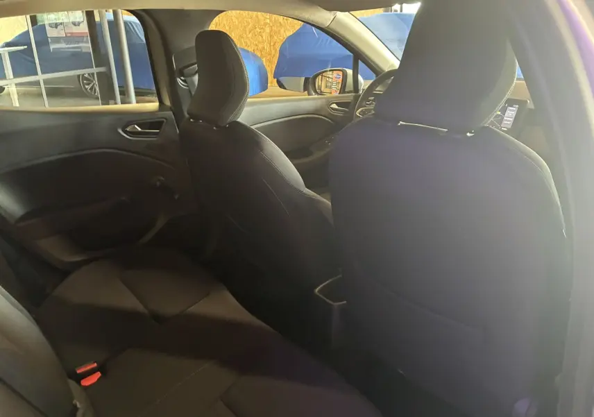 Vue intérieure arrière côté gauche d'une Renault Clio gris 2022, sièges tissu noir et tableau de bord visible au loin.