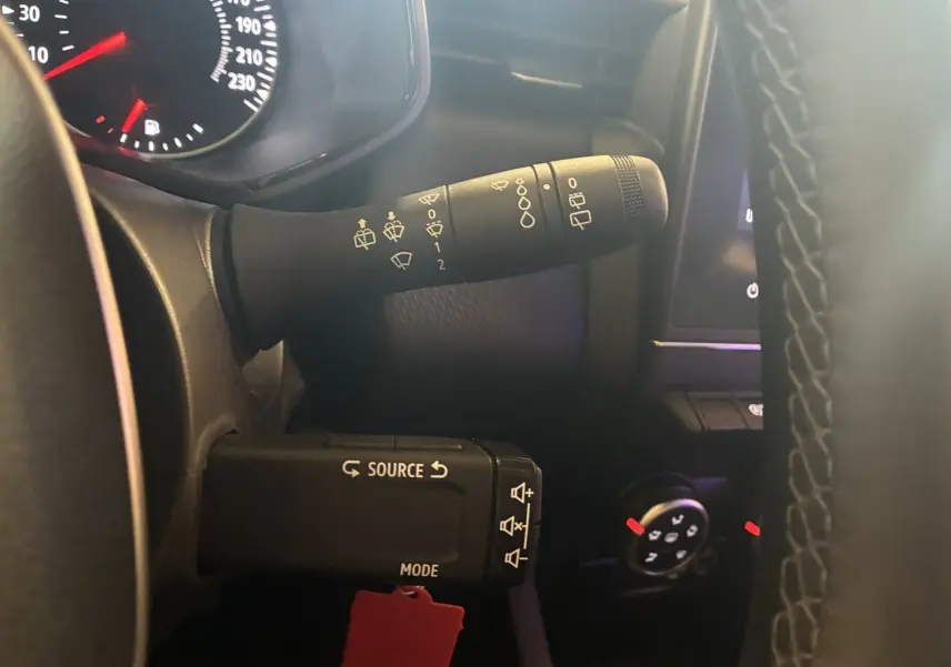 Gros plan sur les commandes au volant d'une Renault Clio 1.5 Blue dCi Business 2022, intérieur noir et tableau de bord partiel.