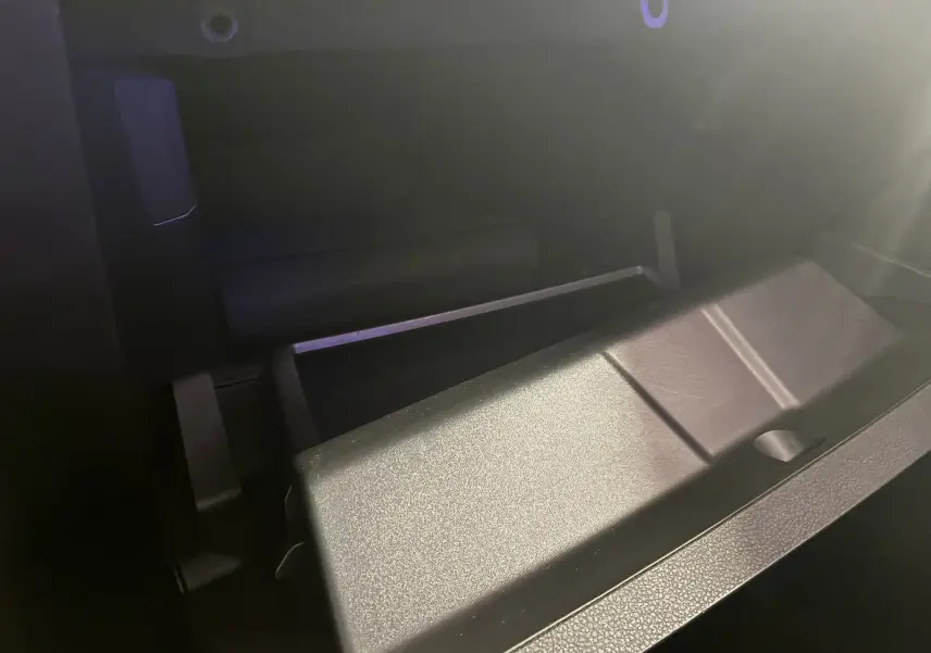 Gros plan sur le rangement intérieur noir en tissu de la Renault Clio 1.5 BlueDCI Business 2022, éclairage tamisé.