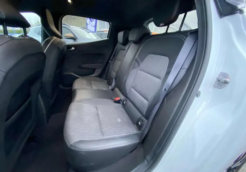 Vue intérieure côté droit montrant la banquette arrière en similicuir tissu gris d'une Renault Clio blanche 2023.