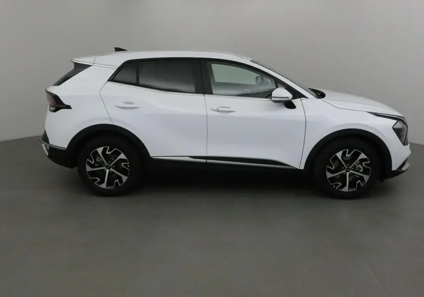 Profil côté droit du Kia Sportage blanc 2025 avec jantes alliage et lignes modernes distinctives.