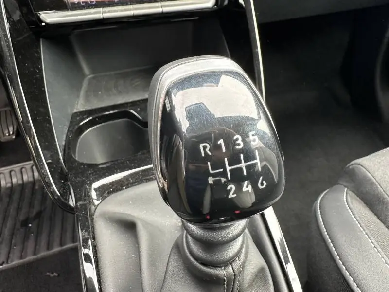 Gros plan sur le levier de vitesses manuel noir de la Citroën C3 1.2 Turbo 100ch MAX 2025, intérieur gris et noir.