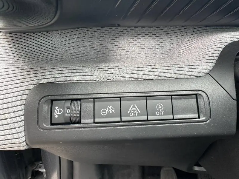 Gros plan sur les boutons de commande côté gauche du tableau de bord de la Citroën C3 Gris Mercury 2025.