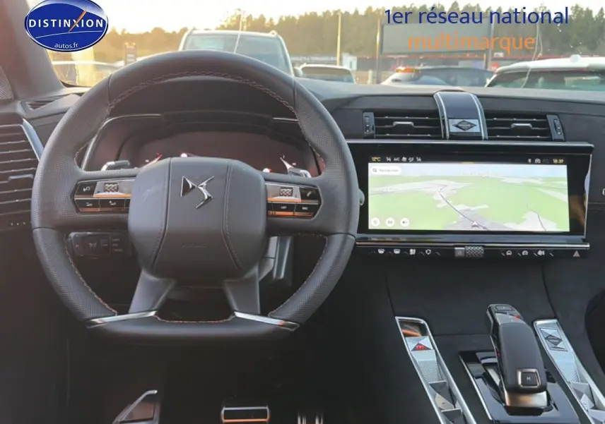 Vue intérieure centrée sur le volant DS et l'écran tactile large du tableau de bord du DS7 noir 2026.