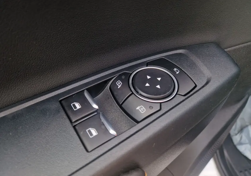 Gros plan sur les commandes de réglage des vitres et des rétroviseurs sur la porte côté conducteur du Ford Ranger Super Cabine gris Iconic.