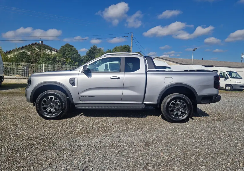 Ford Ranger Super Cabine Wildtrak gris iconic vu de profil côté gauche, avec jantes noires et benne ouverte.