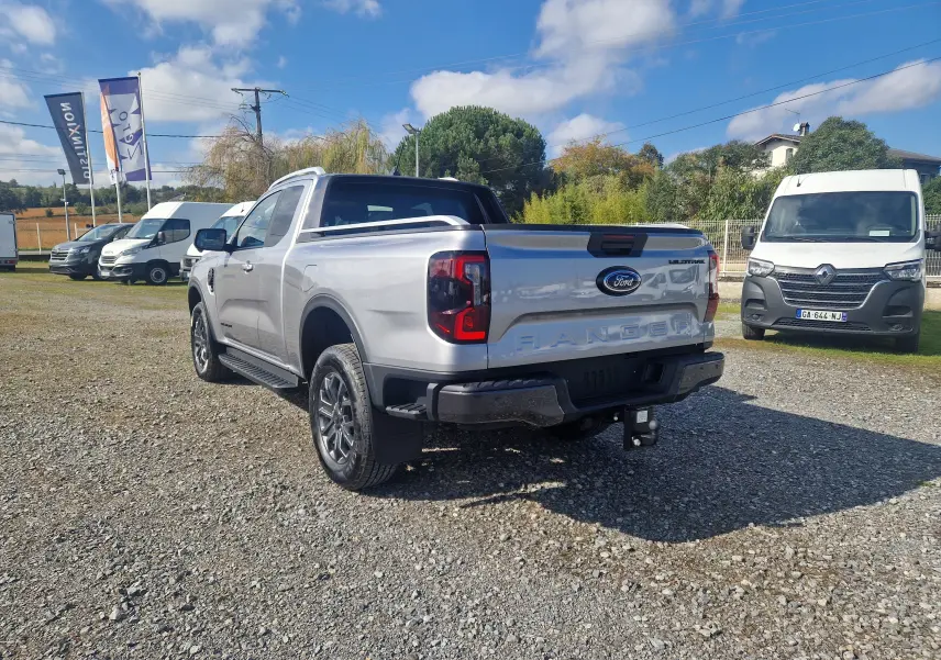 Ford Ranger Super Cabine gris iconic vu en 3/4 arrière droit, avec attelage et protections de benne visibles.