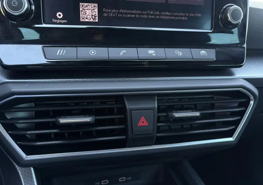 Détail du tableau de bord de la SEAT Leon 2024, montrant les aérateurs centraux et les commandes multimédia.