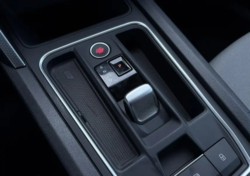 Vue rapprochée de la console centrale avec levier de vitesses automatique et bouton start/stop sur SEAT Leon gris argent 2024