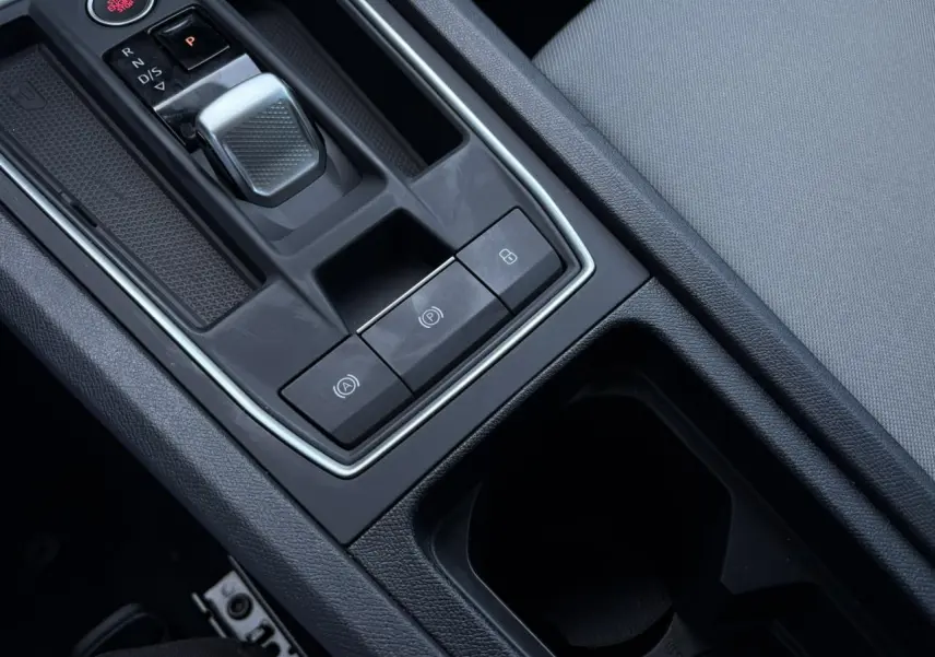 Gros plan sur la console centrale du SEAT LEON 2024 gris argent, mettant en valeur la boîte auto et les commandes électroniques.