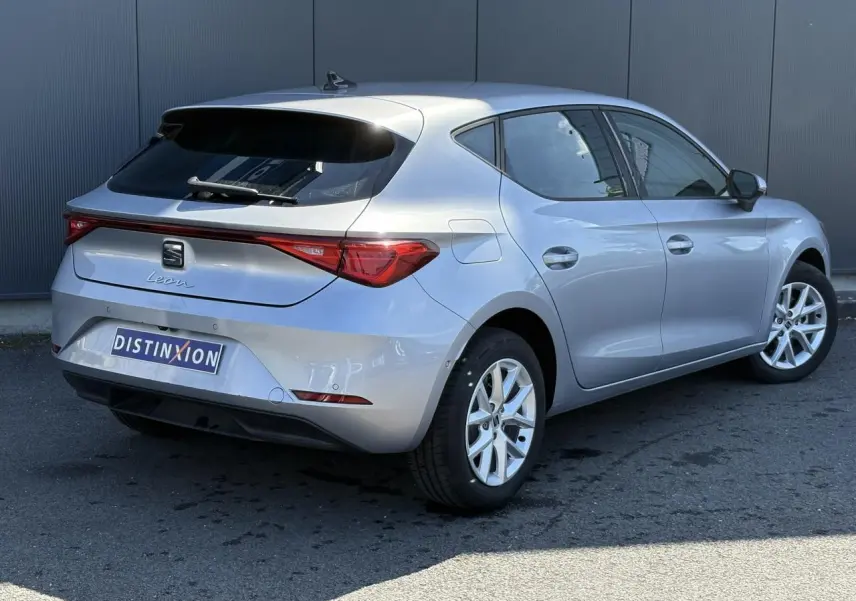 Vue 3/4 arrière droite d'une SEAT Leon 2024 gris argent avec vitres arrière surteintées et jantes alliage 16 pouces.