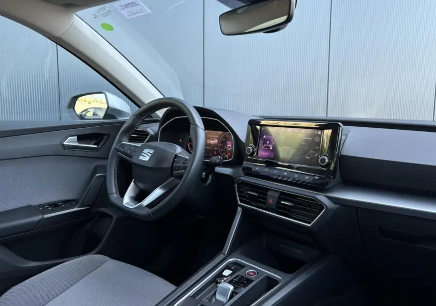 Intérieur de la SEAT LEON 2024 vu côté conducteur, volant cuir multifonction et écran tactile central.