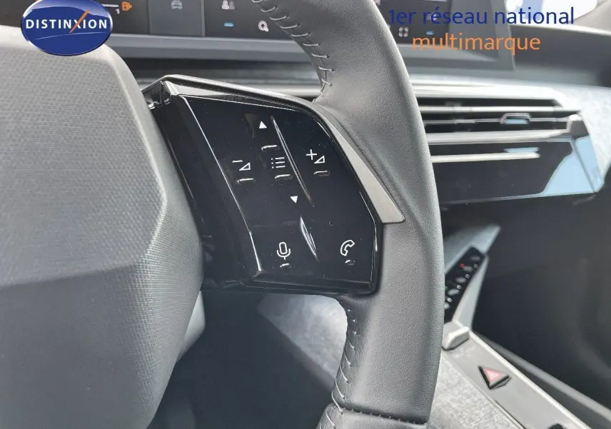 Gros plan sur la partie gauche du volant cuir du Peugeot 3008 Hybrid 2025, avec commandes tactiles intégrées.