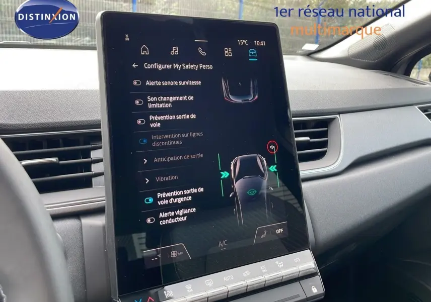 Vue intérieure centrée sur l'écran tactile du tableau de bord du Renault Captur gris Cassiopée, affichant les aides à la conduite.