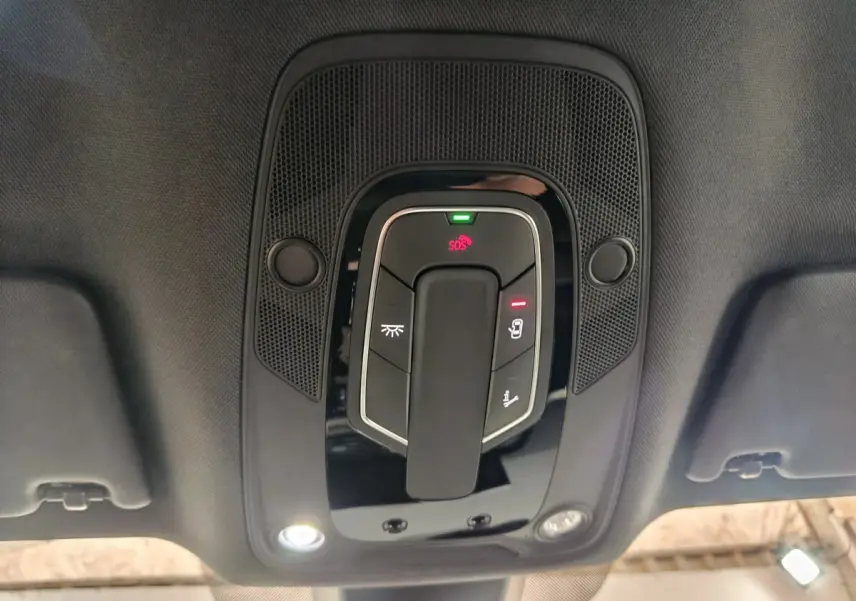 Plafonnier intérieur avec commandes lumineuses et bouton SOS de l'Audi Q5 hybride rechargeable 2023, vue en contre-plongée.