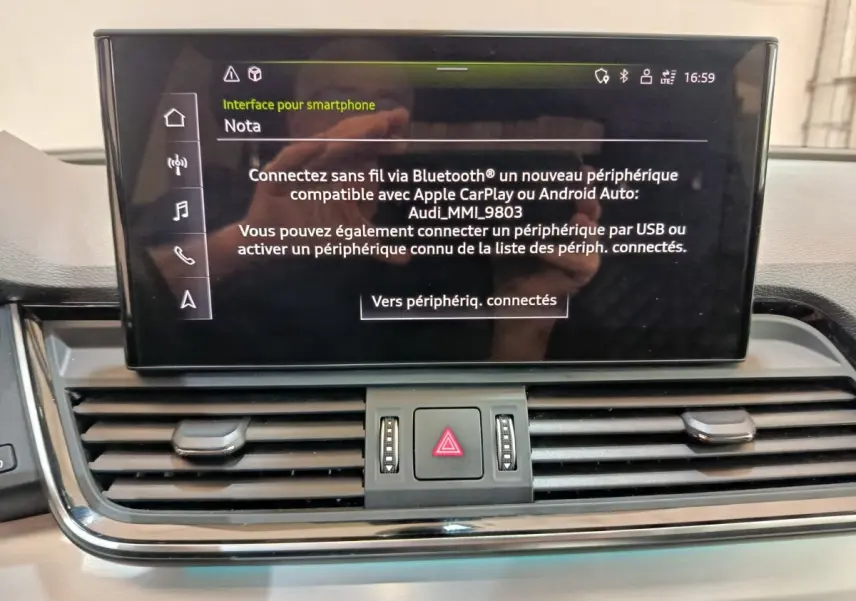 Écran central tactile affichant l'interface smartphone dans l'habitacle d'un Audi Q5 gris clair 2023 hybride rechargeable.
