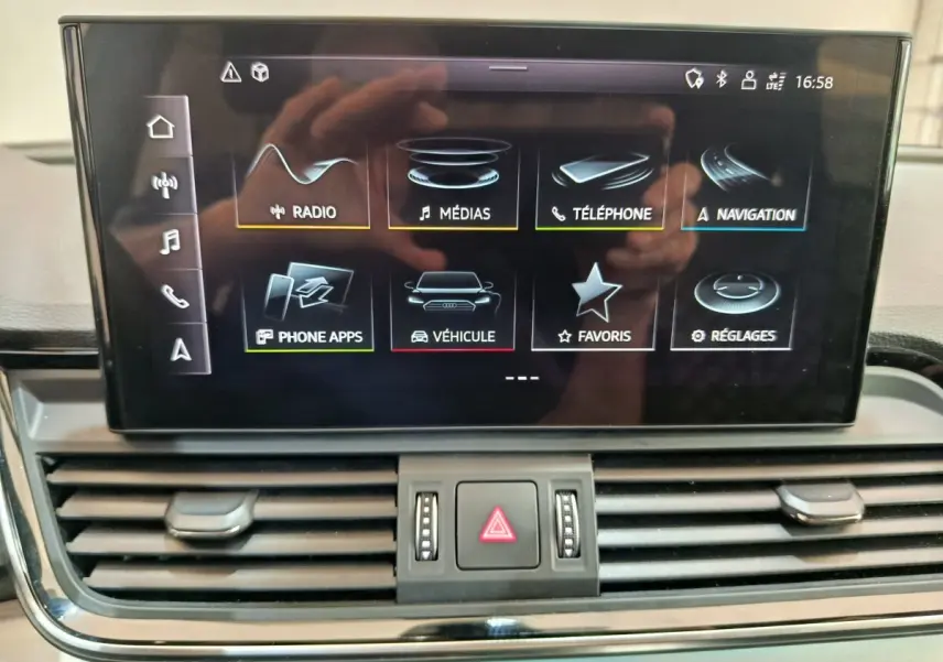 Écran central tactile de l'Audi Q5 2023 gris clair affichant le menu multimédia et navigation.