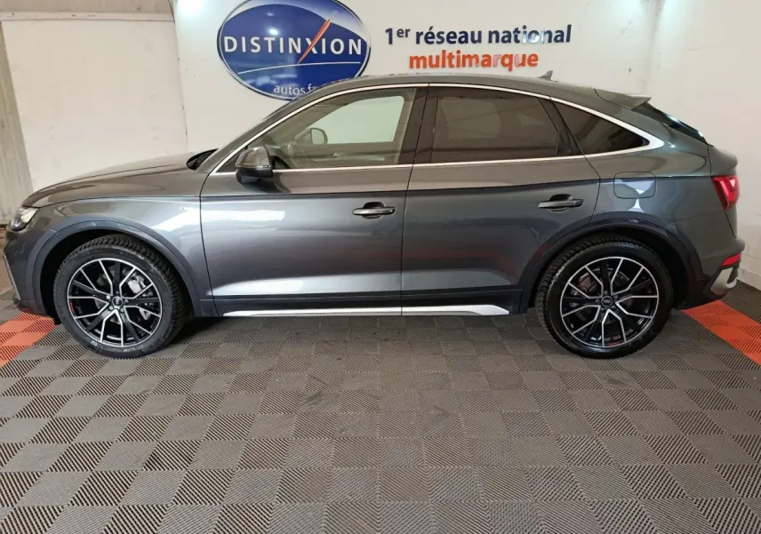 Audi Q5 gris clair 2023 hybride rechargeable, vue profil côté gauche avec jantes noires et détails chromés.