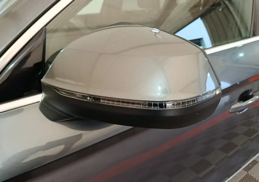 Gros plan sur le rétroviseur côté gauche gris clair de l'Audi Q5 2023 hybride rechargeable avec clignotant intégré.