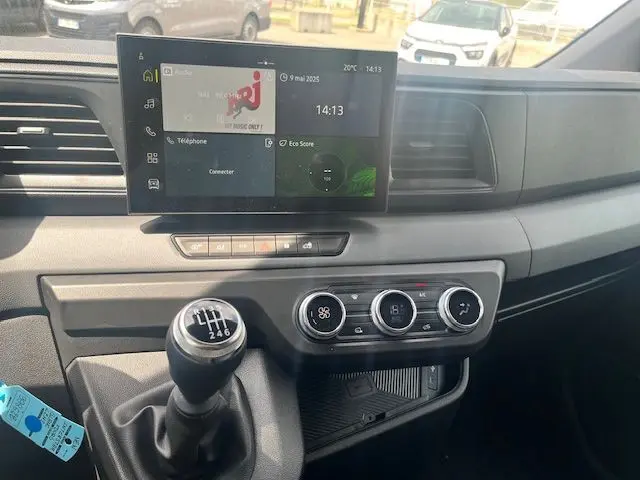 Intérieur du Nissan Interstar Fourgon 2025 montrant la console centrale avec écran tactile et levier de vitesses manuel.