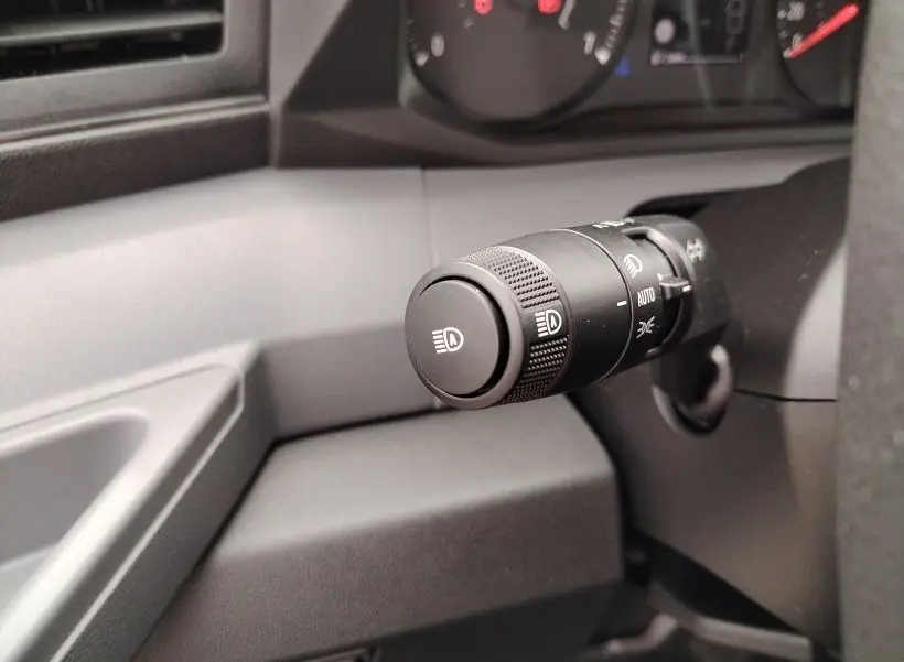 Gros plan sur la commande des phares du Nissan Interstar Fourgon 2026, intérieur gris et noir.