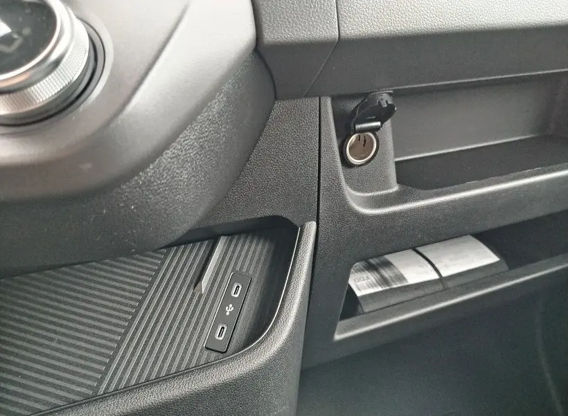 Détail intérieur du tableau de bord noir du Nissan Interstar Fourgon avec prise USB et allume-cigare visible.