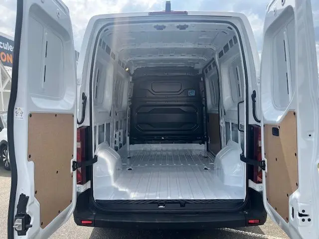 Vue arrière du Nissan Interstar Fourgon blanc 2025 avec portes ouvertes montrant l'espace de chargement vide et clair.