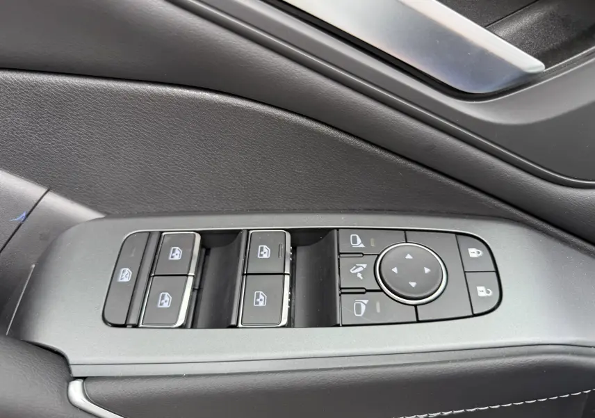 Panneau de commandes des vitres et rétroviseurs côté gauche intérieur noir du Nissan Qashqai blanc nacré 2025.