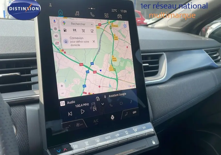 Écran tactile central du Renault Captur E-Tech hybride 2025, affichant une carte GPS, intérieur noir et gris.