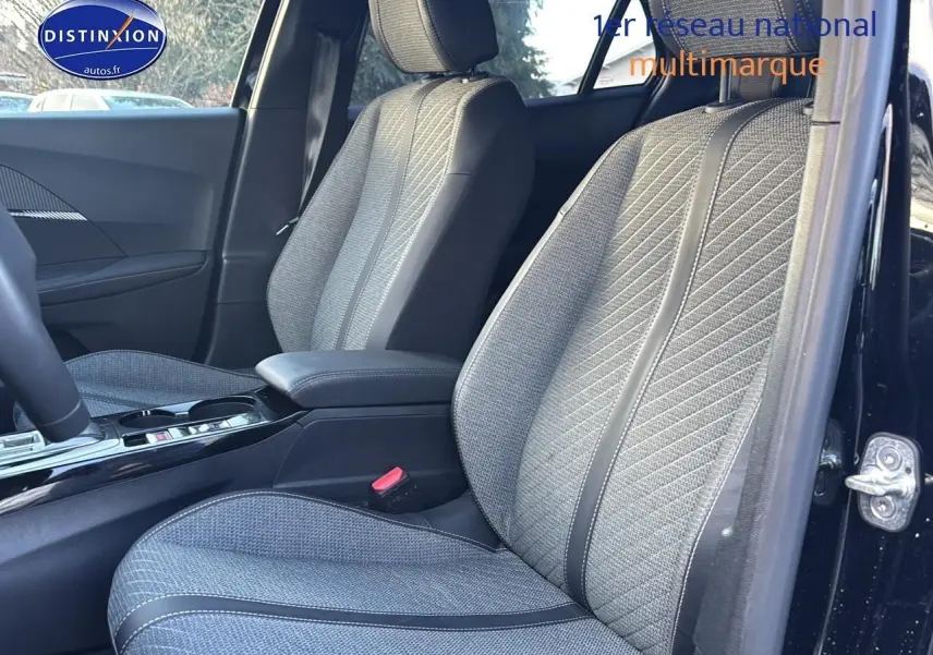 Vue intérieure côté conducteur sur les sièges avant gris texturés du Peugeot 2008 noir 2025, avec accoudoir central.