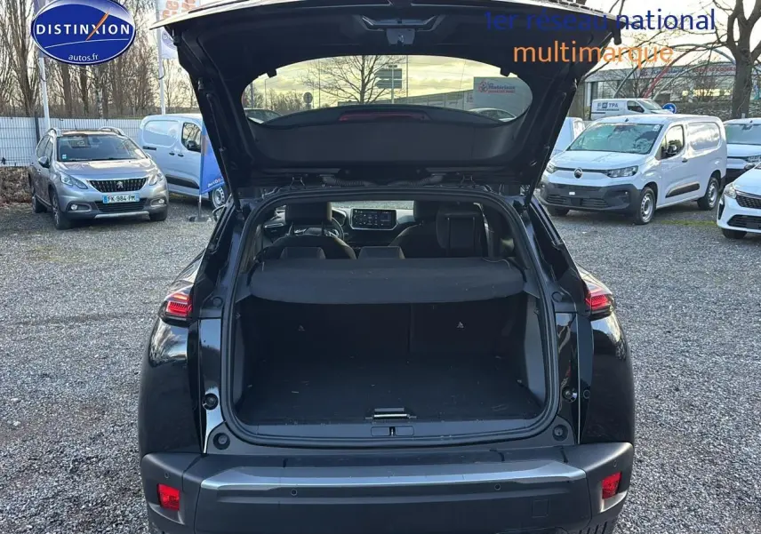 Vue arrière d'une Peugeot 2008 noire 2025 avec coffre ouvert, feux arrière LED et sortie d'échappement chromée visible.