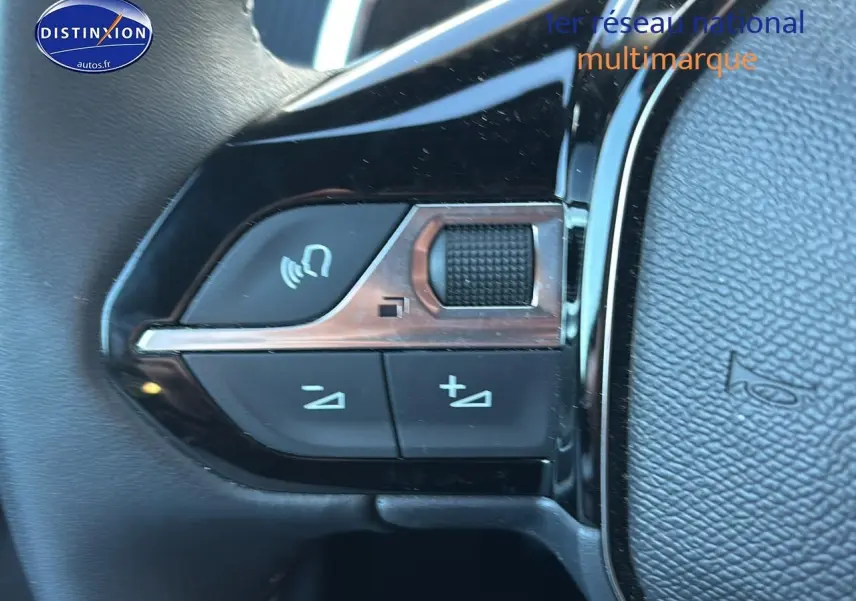Gros plan sur les commandes de volume et appel du volant noir du Peugeot 2008 1.2 hybrid 145 allure e-dcs6.