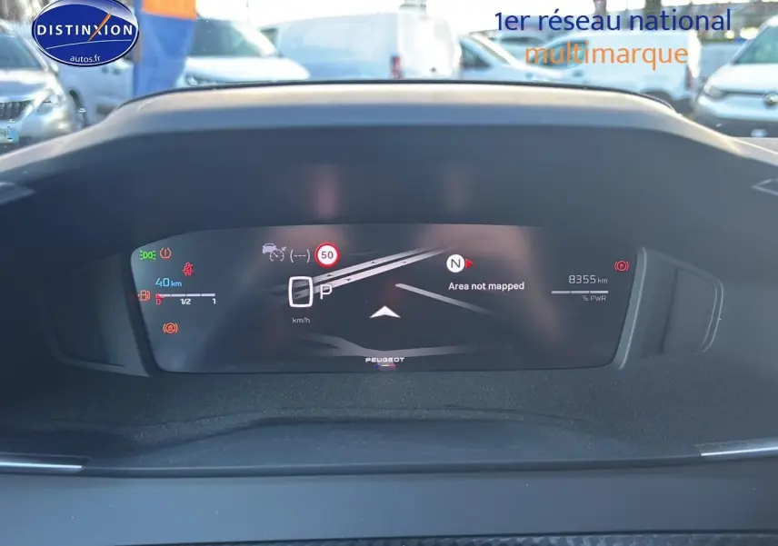 Vue rapprochée du tableau de bord numérique du Peugeot 2008 noir, affichant la vitesse et les alertes de conduite.