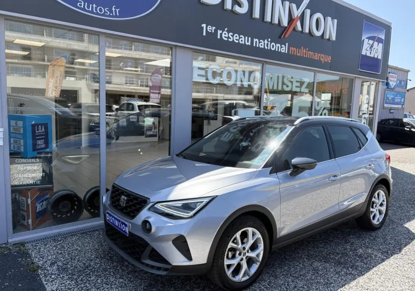 SEAT Arona 2024 gris GRS en 3/4 avant droit, jantes alliage 16 pouces et calandre noire distinctive.