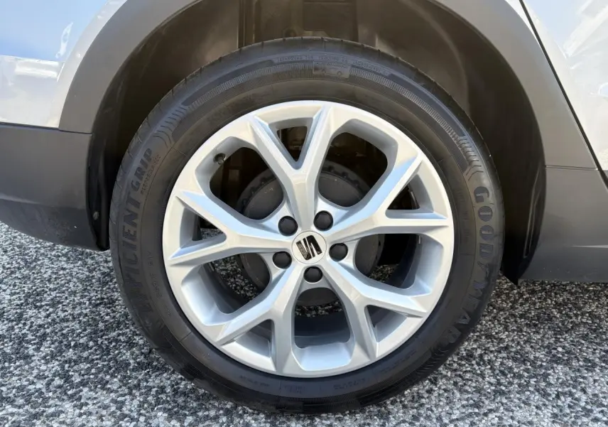 Gros plan sur la jante alliage 16 pouces argentée avec logo SEAT sur roue avant droite du SEAT Arona rouge GRS.