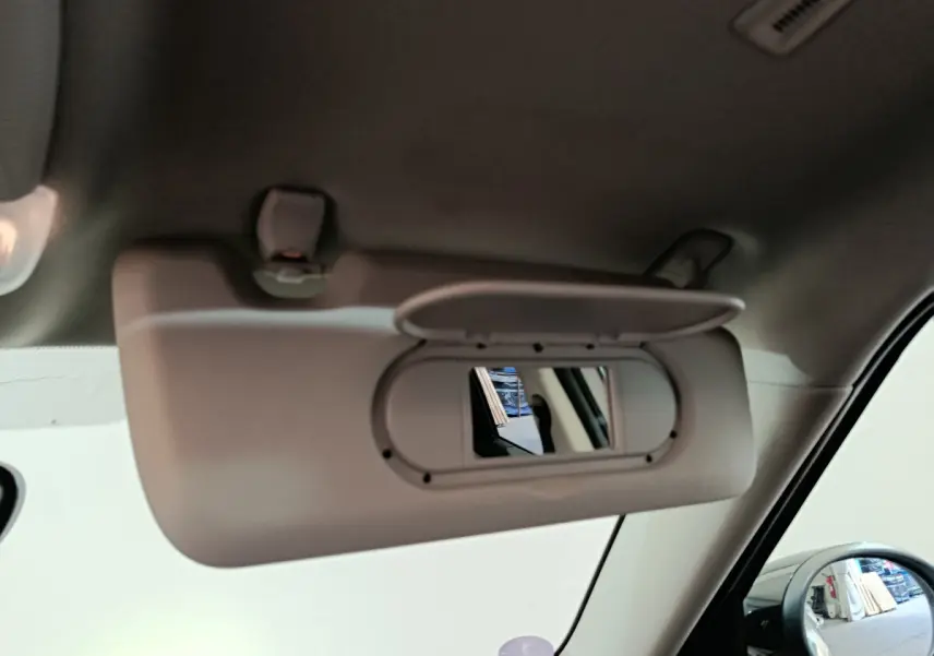 Détail du pare-soleil côté gauche avec miroir intégré dans l’habitacle du MINI Countryman blanc hybride rechargeable.