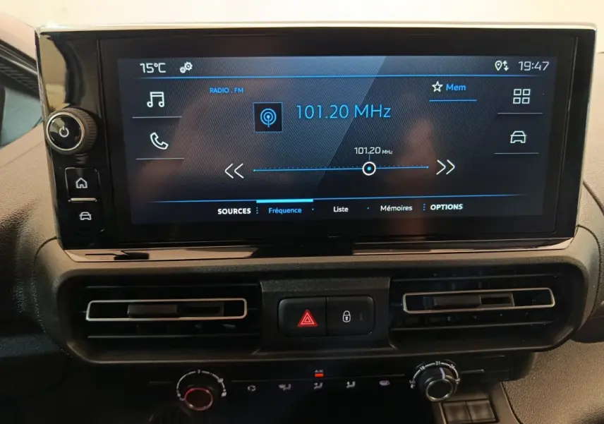 Écran tactile central du tableau de bord du Peugeot Partner blanc 2025 affichant la radio FM à 101,20 MHz.