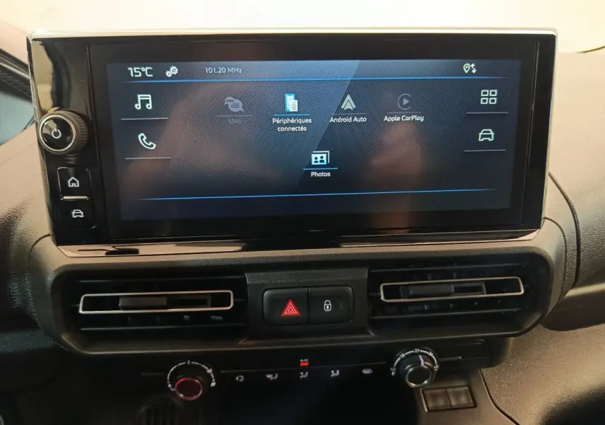 Vue rapprochée de l'écran tactile central et des commandes de climatisation du Peugeot Partner blanc 2025.