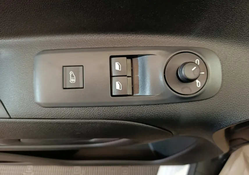 Gros plan sur les commandes de réglage des rétroviseurs et des vitres côté conducteur du Peugeot Partner blanc 2025.