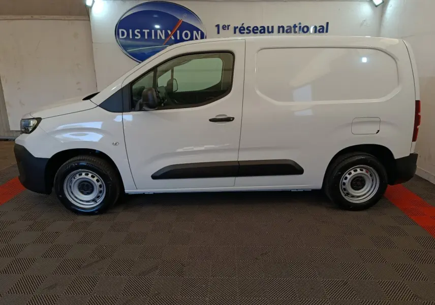 Vue de profil côté gauche d'un Peugeot Partner blanc 2025 avec porte latérale pleine et jantes acier simples.