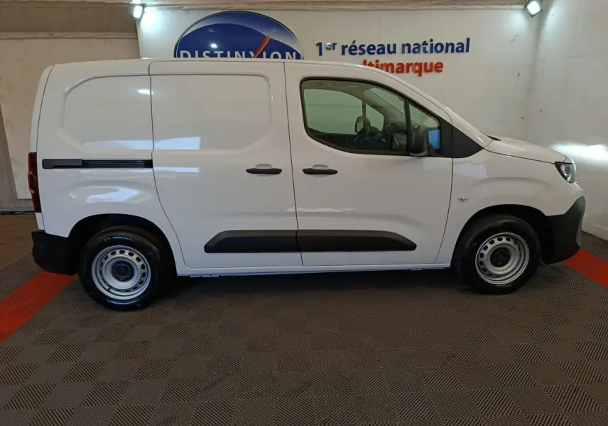 Vue de profil côté droit du Peugeot Partner blanc 2025, utilitaire compact avec protections latérales noires.