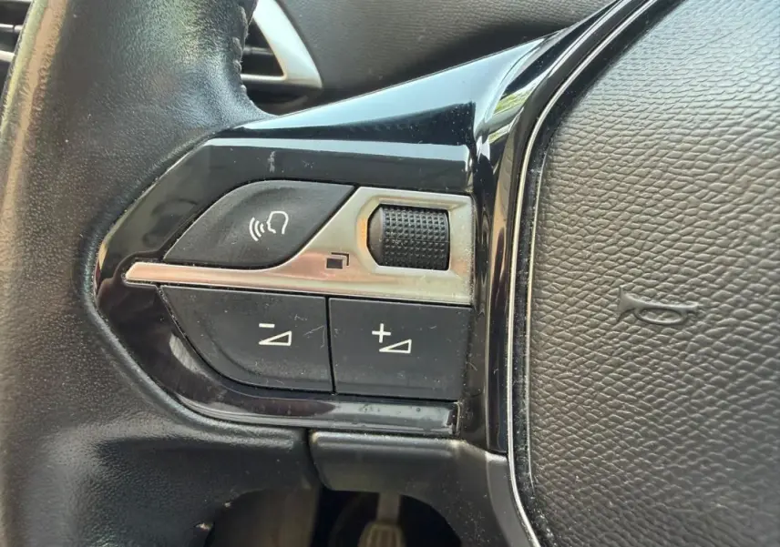Détail des commandes au volant noir du Peugeot 3008 2021, boutons de volume et de téléphone visibles.