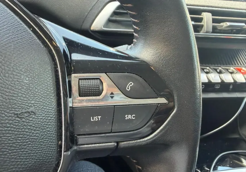 Gros plan sur la partie gauche du volant noir du Peugeot 3008 2021, avec commandes audio et téléphone visibles.