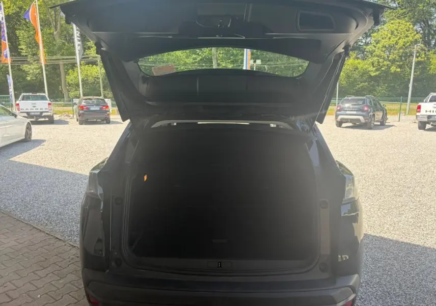 Vue arrière du Peugeot 3008 noir 2021 avec coffre ouvert, mettant en valeur l'espace de chargement vide.