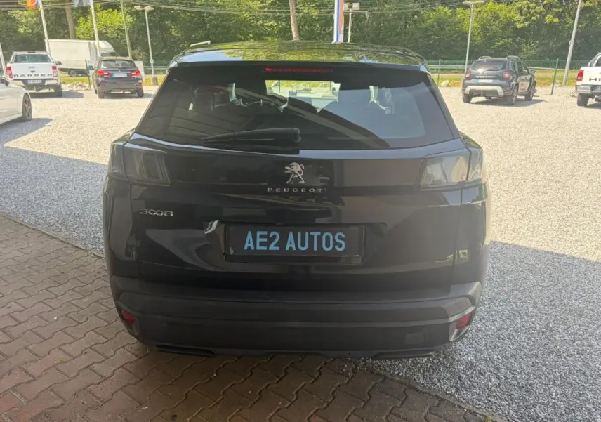 Vue arrière d'un Peugeot 3008 noir 2021, mettant en valeur les feux arrière teintés et le logo central sur un parking extérieur.