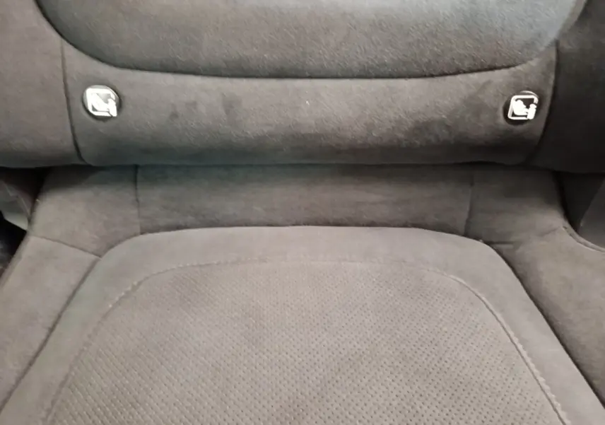 Détail du siège arrière en tissu gris foncé avec ancrages ISOFIX visibles sur un Hyundai Tucson rouge.