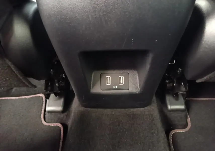 Prise USB double vue en gros plan sous la console centrale arrière d’un Hyundai Tucson rouge.