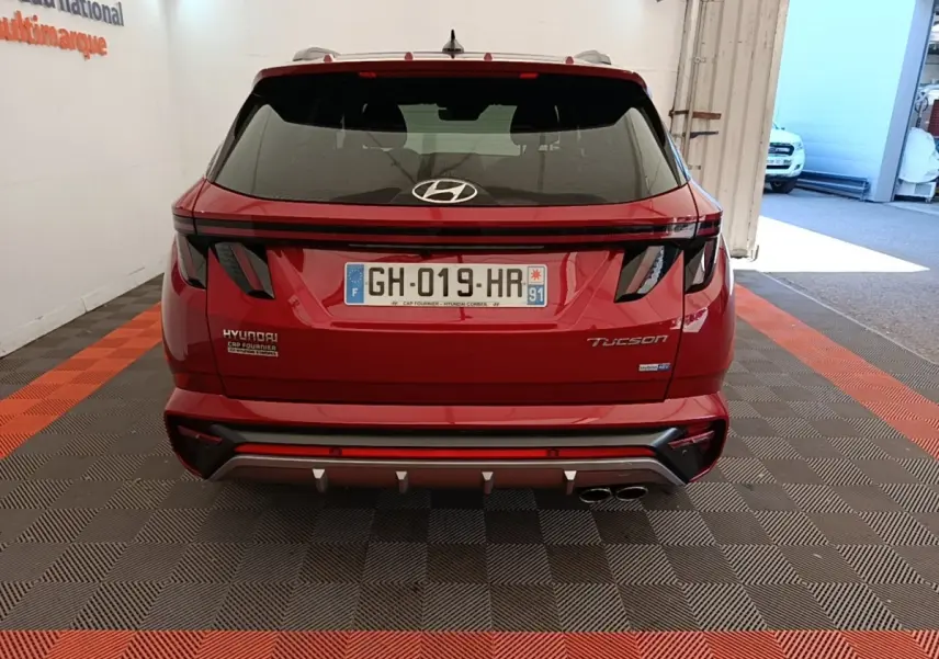 Vue arrière d’un Hyundai Tucson rouge 2022 avec feux LED et double sortie d’échappement chromée.